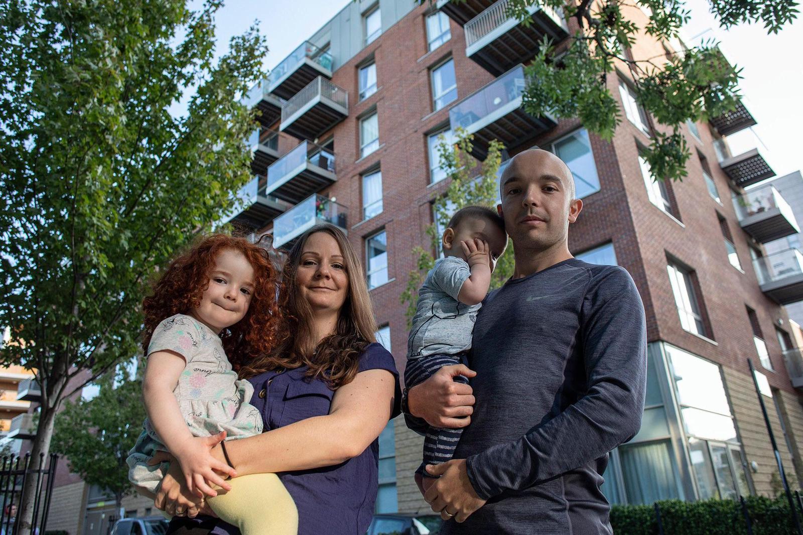 Family of four standing outside a property with a cladding crisis